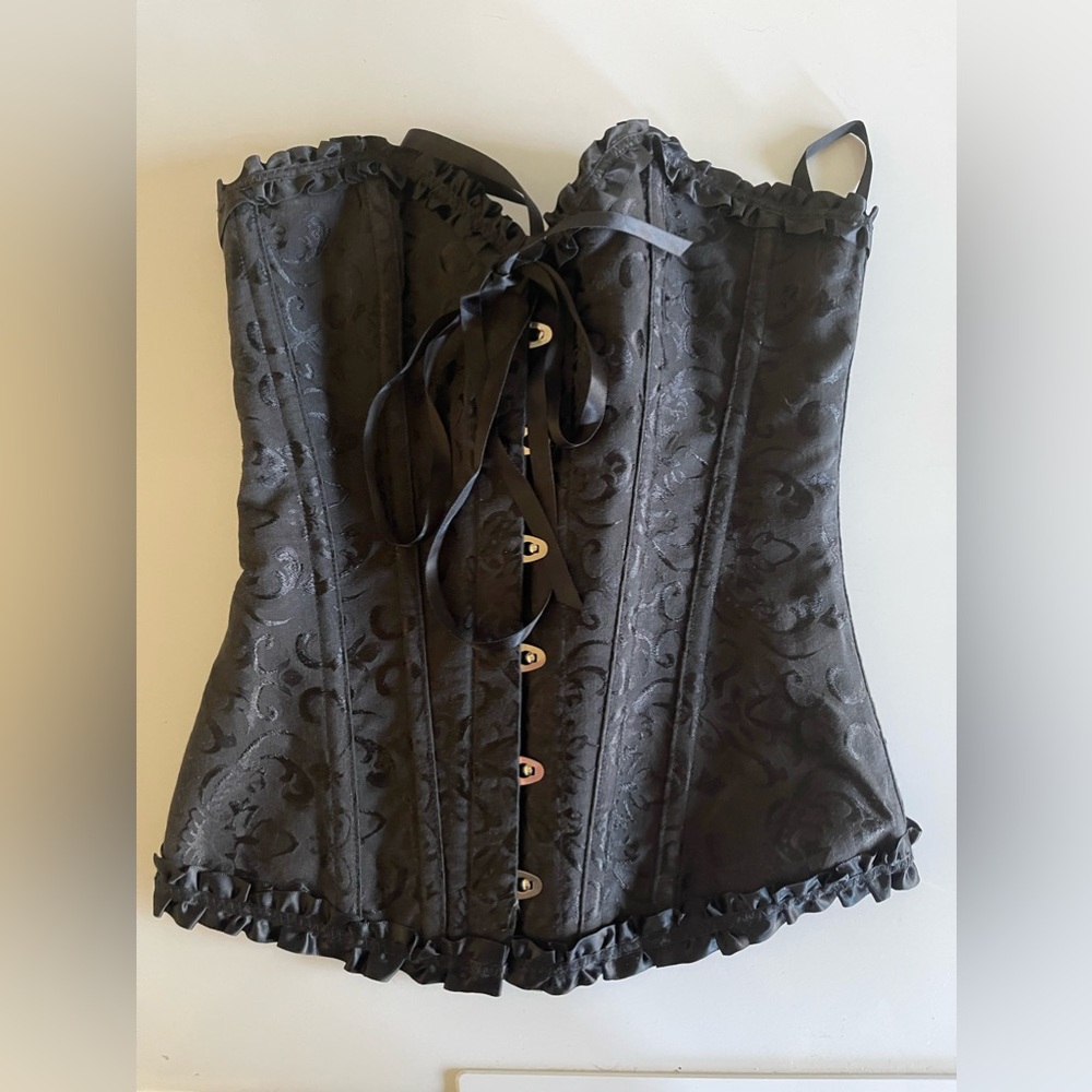 Black size S corset with front clips and back ties.